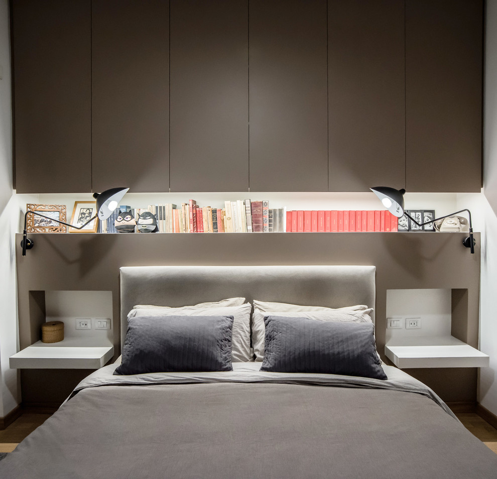 Modelo de dormitorio principal urbano pequeño con paredes beige y suelo de madera clara