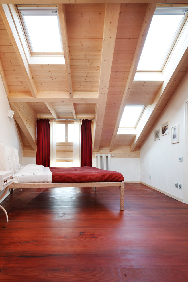 This is an example of a small contemporary master bedroom in Milan with white walls and dark hardwood flooring.