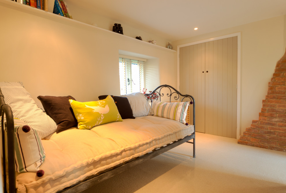 Modelo de dormitorio tipo loft campestre de tamaño medio con paredes beige, suelo beige y moqueta