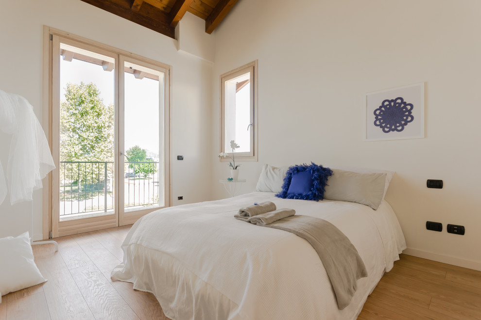 Bild på ett funkis sovrum, med vita väggar, ljust trägolv och beiget golv