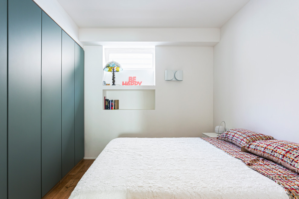 Foto di una grande camera matrimoniale minimalista con pareti bianche, pavimento in legno massello medio e pavimento marrone