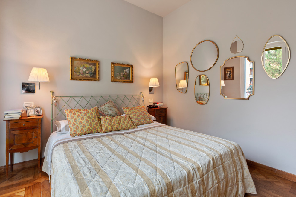 Mediterranes Schlafzimmer mit grauer Wandfarbe, braunem Holzboden und braunem Boden in Bologna