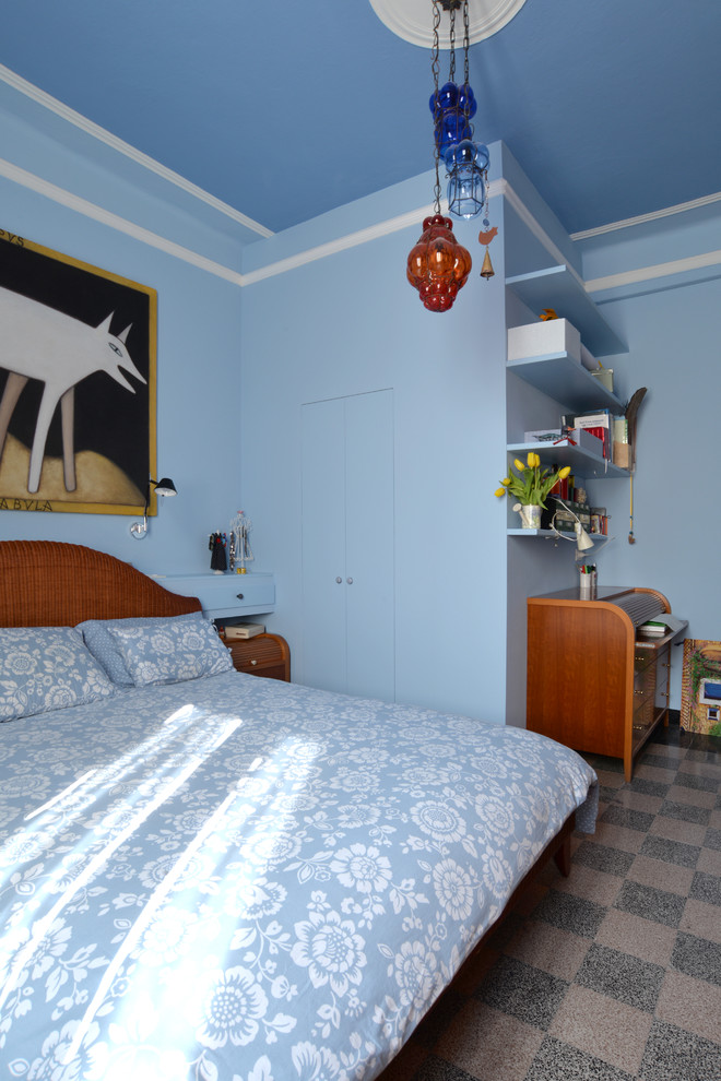 This is an example of a large bohemian master bedroom in Bologna with blue walls and ceramic flooring.