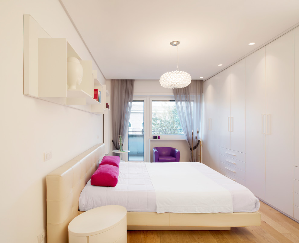 Modernes Schlafzimmer mit weißer Wandfarbe und braunem Holzboden in Rom