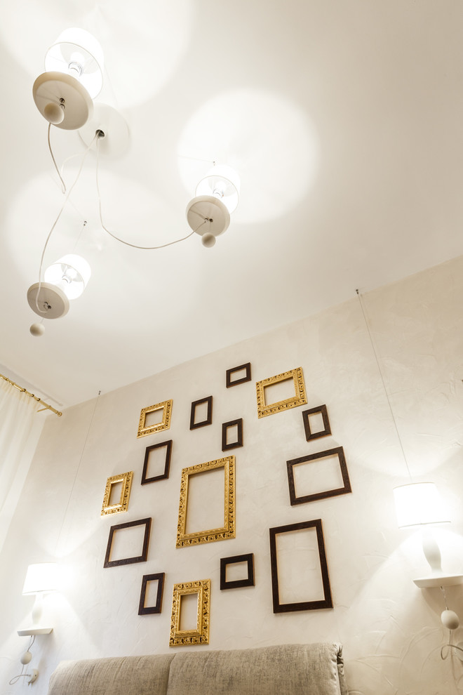 Immagine di una camera matrimoniale eclettica con pareti beige e pavimento in legno massello medio