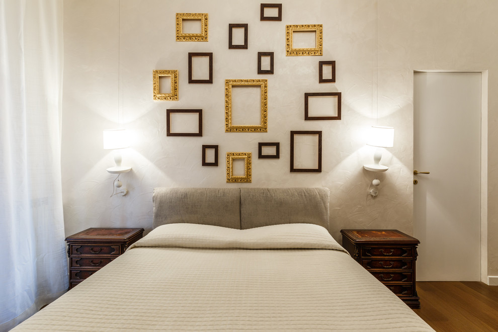 ローマにあるエクレクティックスタイルのおしゃれな主寝室 (ベージュの壁、無垢フローリング)