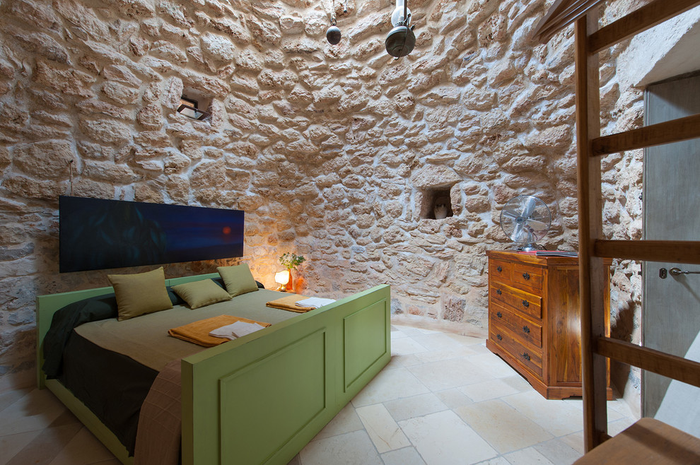 Cette image montre une petite chambre parentale bohème avec un mur beige et un sol en calcaire.