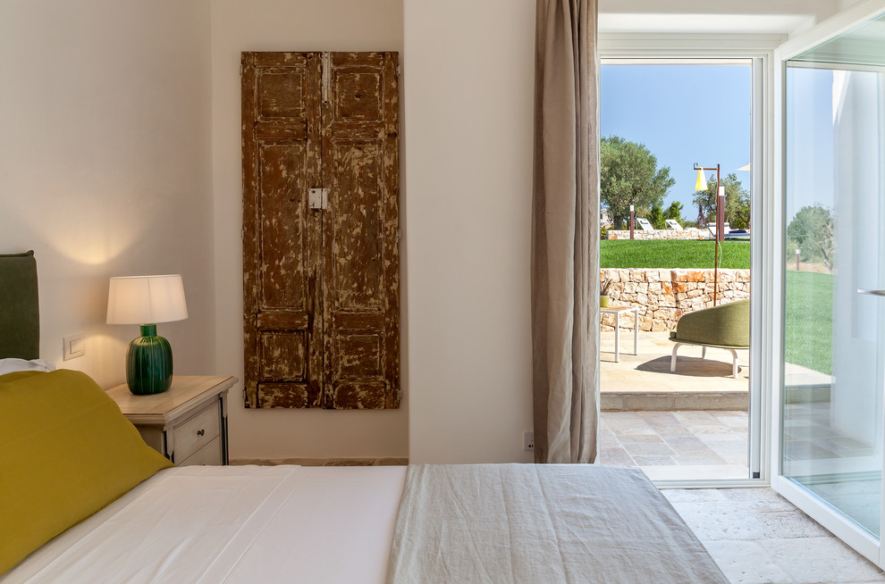 Imagen de dormitorio principal mediterráneo pequeño con paredes blancas y suelo de piedra caliza