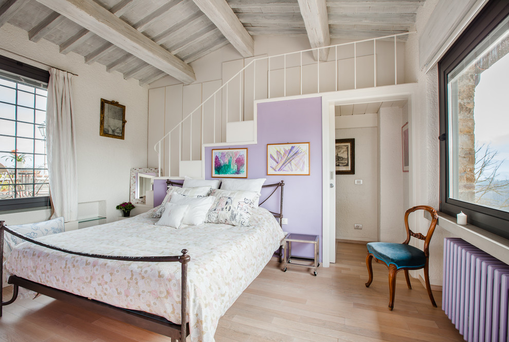 Esempio di un'In mansarda camera da letto tradizionale di medie dimensioni con pareti viola, parquet chiaro e pavimento beige