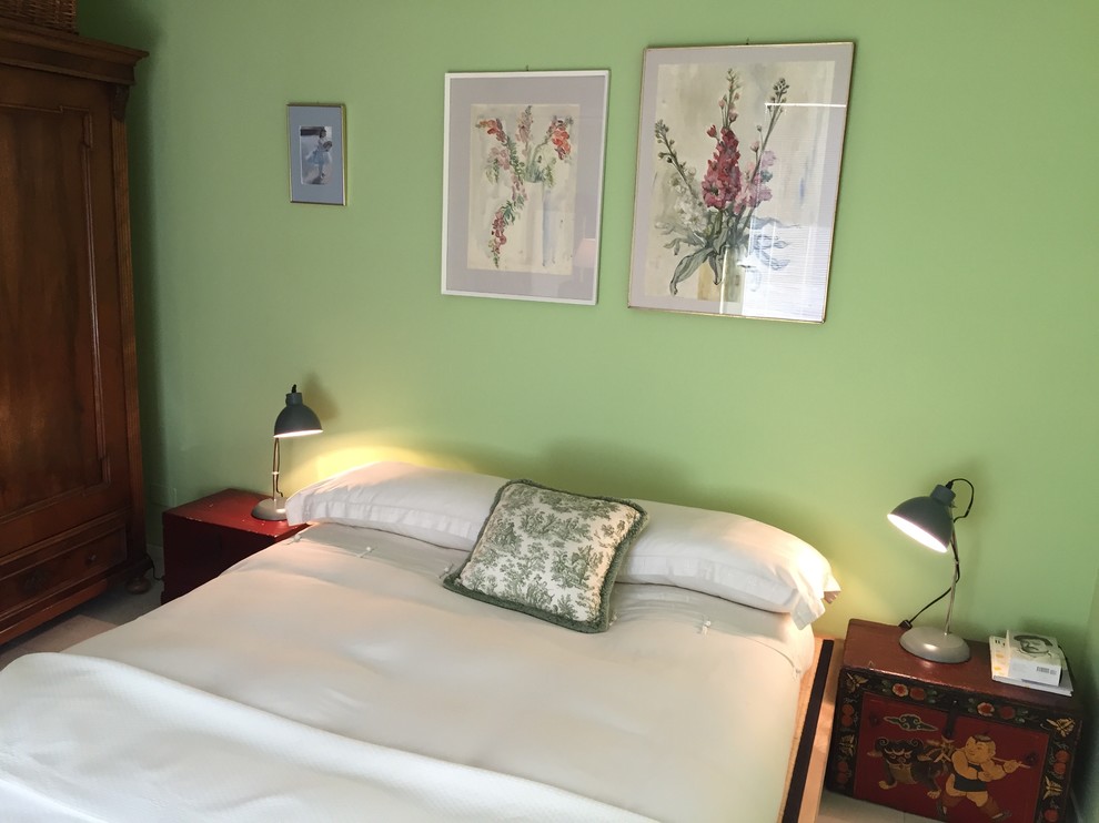 Ejemplo de dormitorio bohemio de tamaño medio con paredes verdes y suelo de baldosas de porcelana