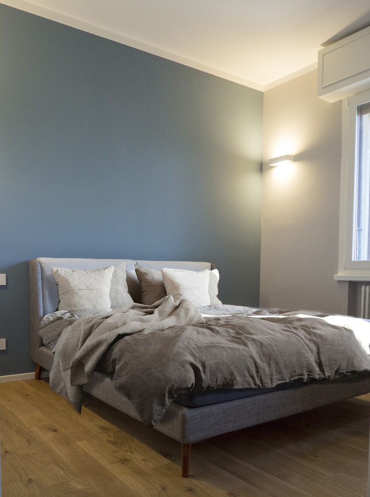 Idee per una camera matrimoniale contemporanea di medie dimensioni con pareti blu, parquet chiaro e pavimento beige