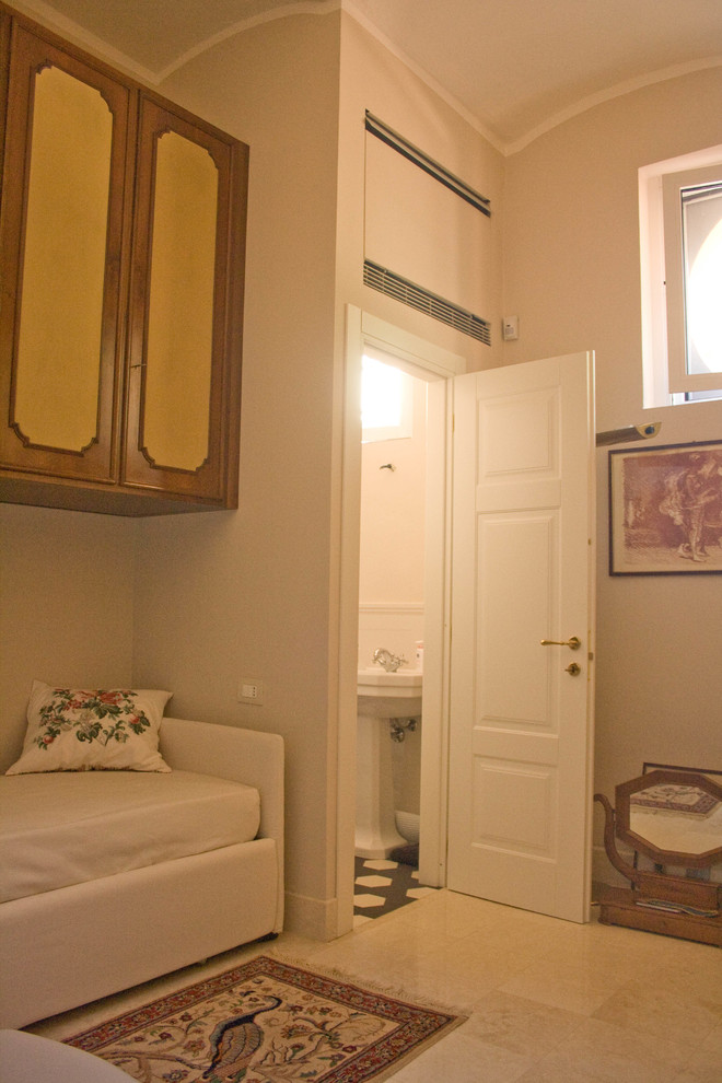 Modelo de dormitorio tradicional de tamaño medio con paredes beige, suelo de mármol y suelo blanco