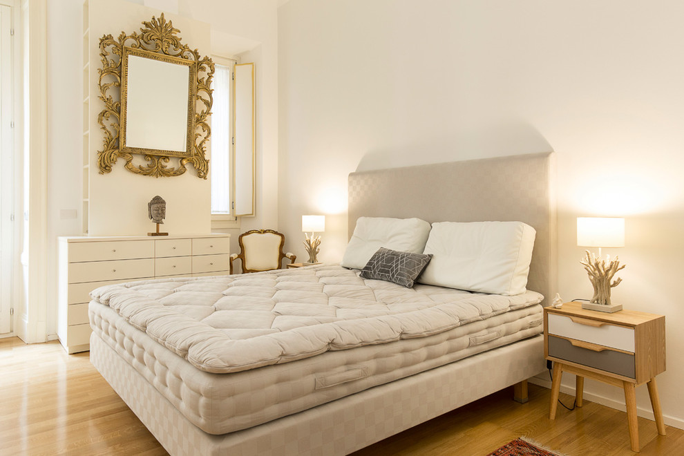 Example of a mid-sized eclectic master medium tone wood floor and brown floor bedroom design in Milan with white walls and no fireplace