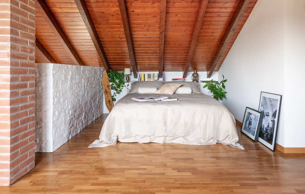 Large scandi bedroom in Milan with white walls, light hardwood flooring and beige floors.