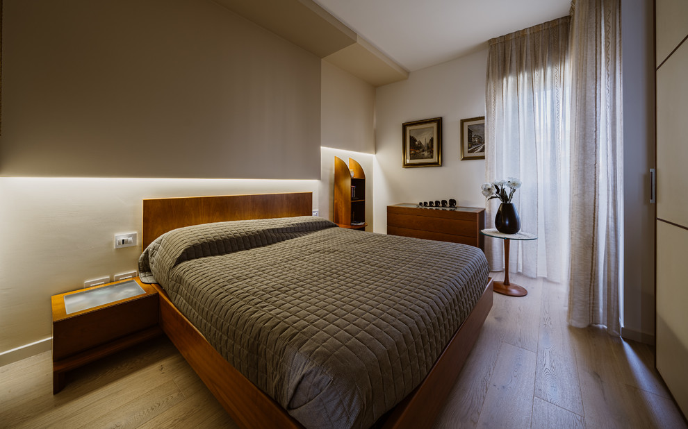 Medium sized contemporary master bedroom in Milan with multi-coloured walls, light hardwood flooring and beige floors.