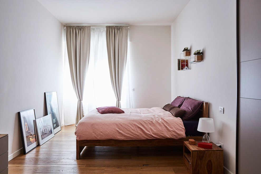 Réalisation d'une chambre parentale minimaliste de taille moyenne avec un mur blanc, parquet foncé, aucune cheminée et un sol marron.