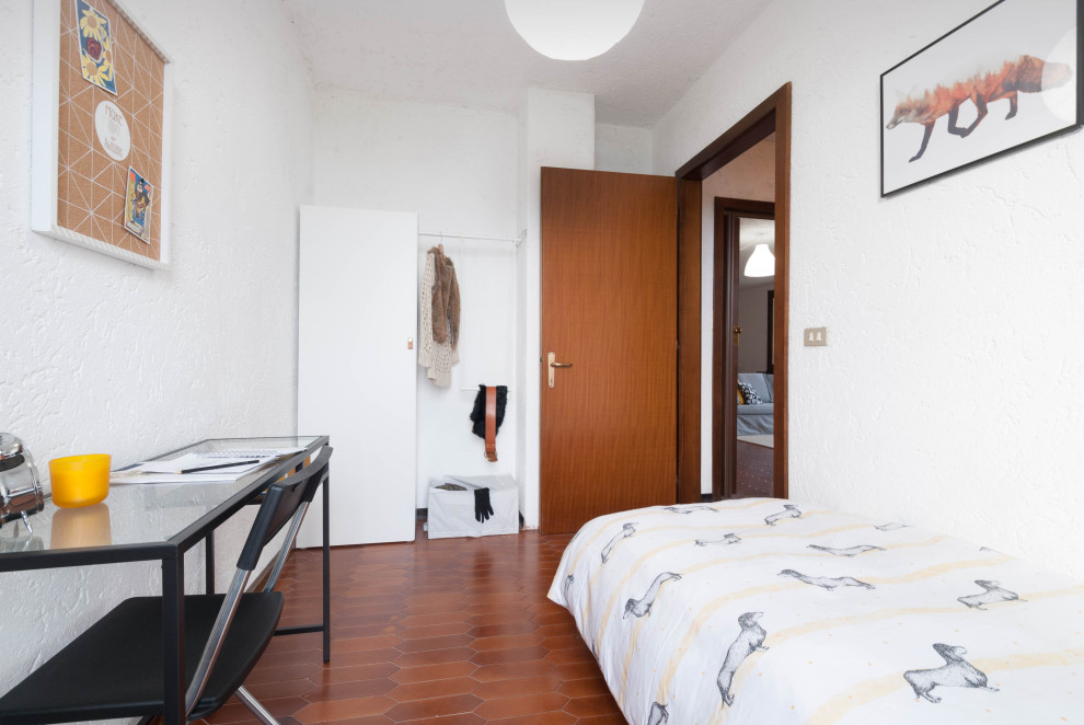 Ejemplo de habitación de invitados nórdica de tamaño medio con paredes blancas, suelo de baldosas de porcelana y suelo marrón