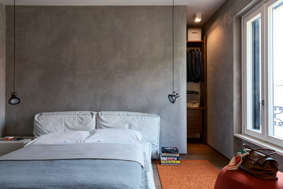 Contemporary grey and brown bedroom in Milan with dark hardwood flooring and brown floors.