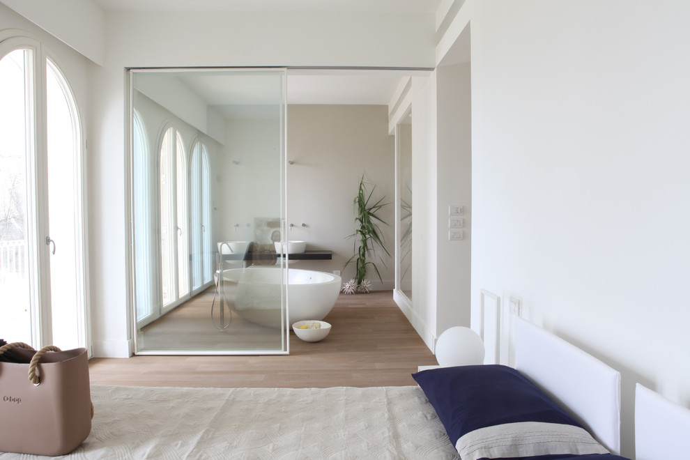 На фото: большая хозяйская спальня в морском стиле с белыми стенами и светлым паркетным полом с