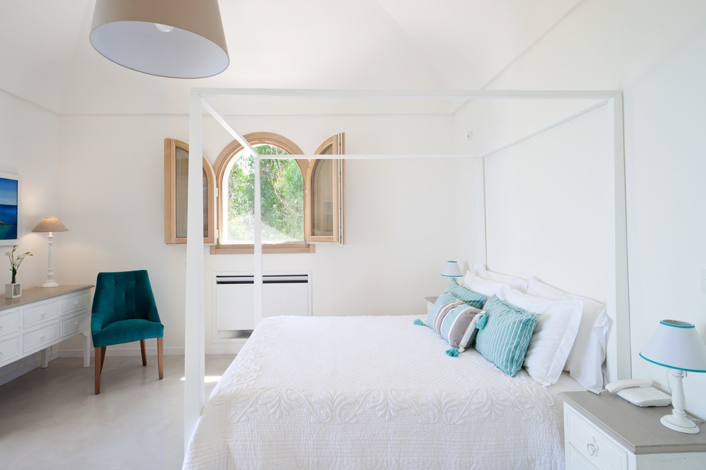 На фото: большая хозяйская спальня в средиземноморском стиле с белыми стенами и бетонным полом с