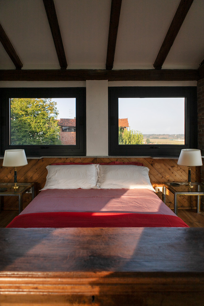 Immagine di una camera degli ospiti stile rurale di medie dimensioni con pareti bianche, pavimento in legno verniciato e pavimento marrone