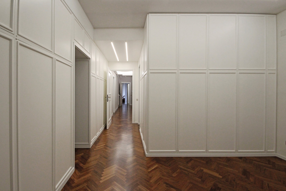 Immagine di una grande camera matrimoniale classica con pareti bianche, pavimento in legno verniciato e pavimento marrone