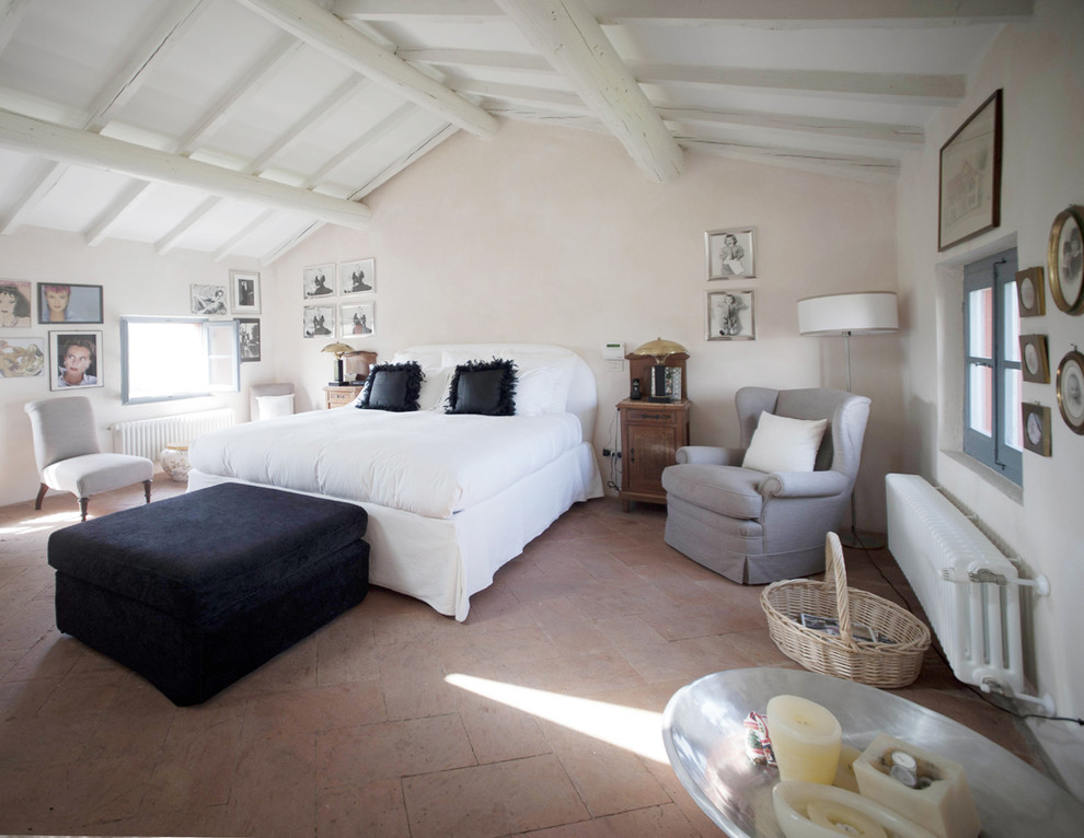 Ejemplo de dormitorio principal campestre grande con paredes beige y suelo de baldosas de terracota