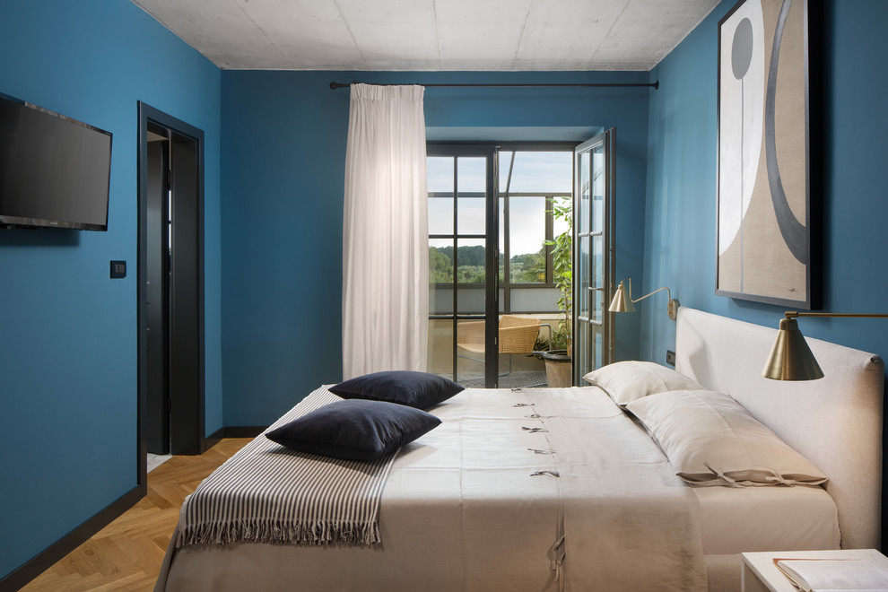 Idee per una camera da letto mediterranea con pareti blu, pavimento in legno massello medio e pavimento marrone