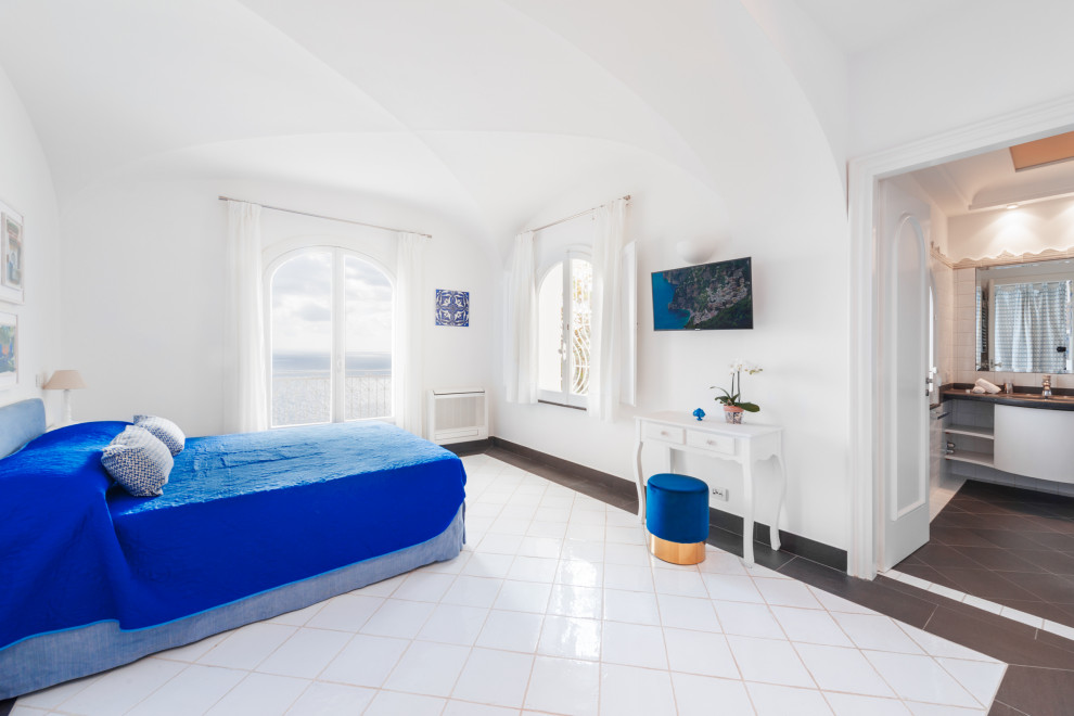 Идея дизайна: хозяйская спальня среднего размера в средиземноморском стиле с белыми стенами, полом из керамогранита, белым полом, сводчатым потолком и телевизором