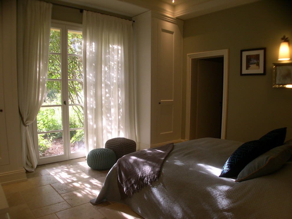 Ejemplo de habitación de invitados mediterránea de tamaño medio con suelo beige, paredes verdes y suelo de piedra caliza