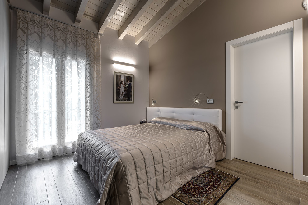 Imagen de dormitorio principal tradicional con paredes beige y suelo de madera clara