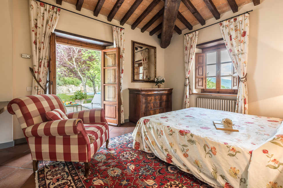 Ispirazione per una camera matrimoniale stile rurale di medie dimensioni con pareti beige, pavimento in terracotta e pavimento rosso