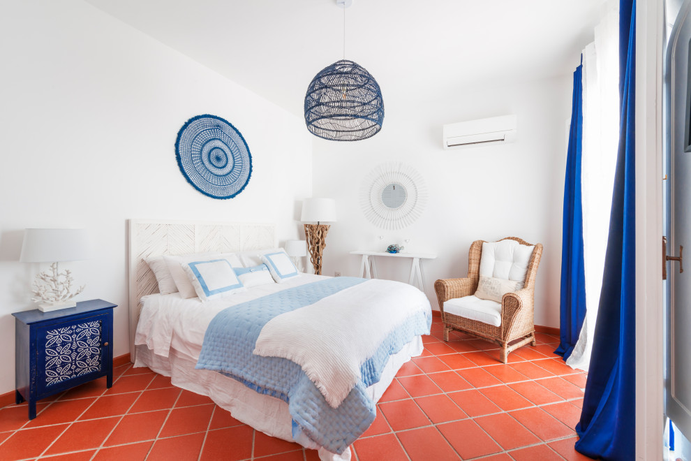 Стильный дизайн: хозяйская спальня среднего размера в средиземноморском стиле с белыми стенами, полом из терракотовой плитки и коричневым полом - последний тренд