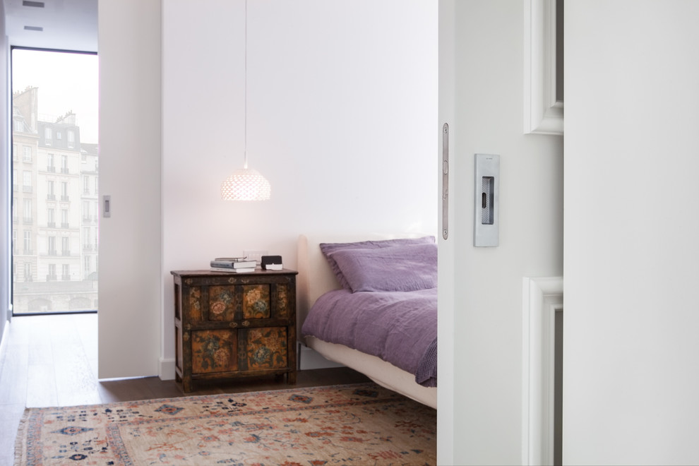 Immagine di una camera da letto stile loft minimal con pareti bianche e pavimento marrone
