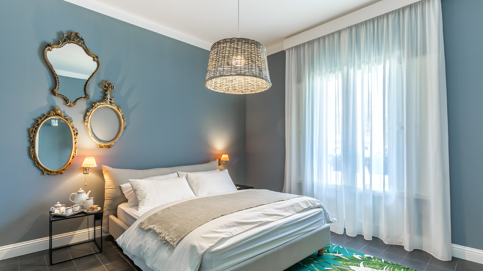 Beach style master bedroom in Other with grey floors and blue walls.