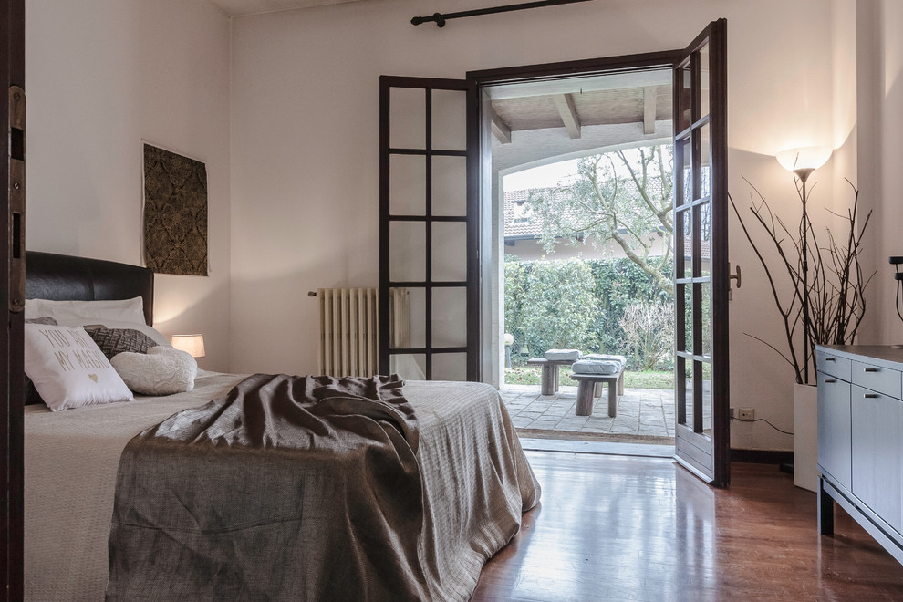 他の地域にある地中海スタイルのおしゃれな寝室 (白い壁、無垢フローリング、茶色い床) のインテリア