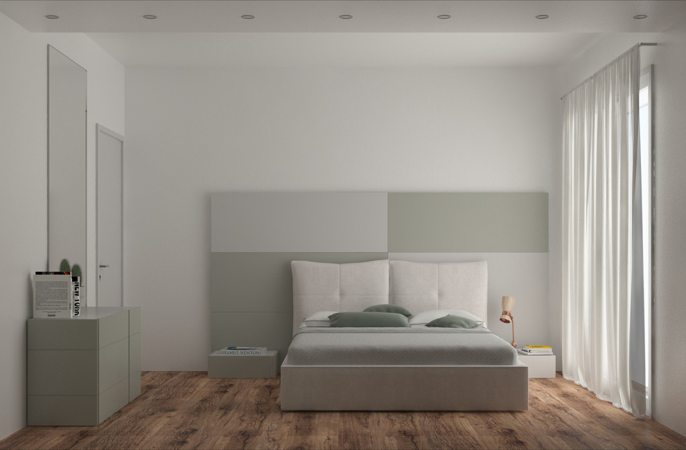 Immagine di una camera matrimoniale design con pareti bianche e pavimento in legno massello medio