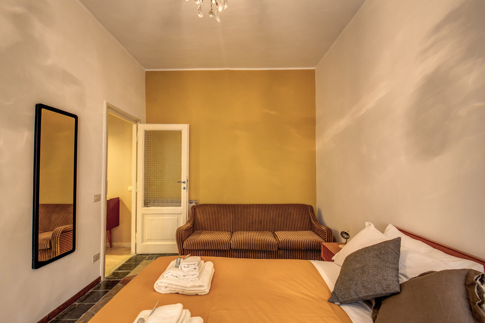 На фото: хозяйская спальня среднего размера в стиле ретро с желтыми стенами, бетонным полом и разноцветным полом