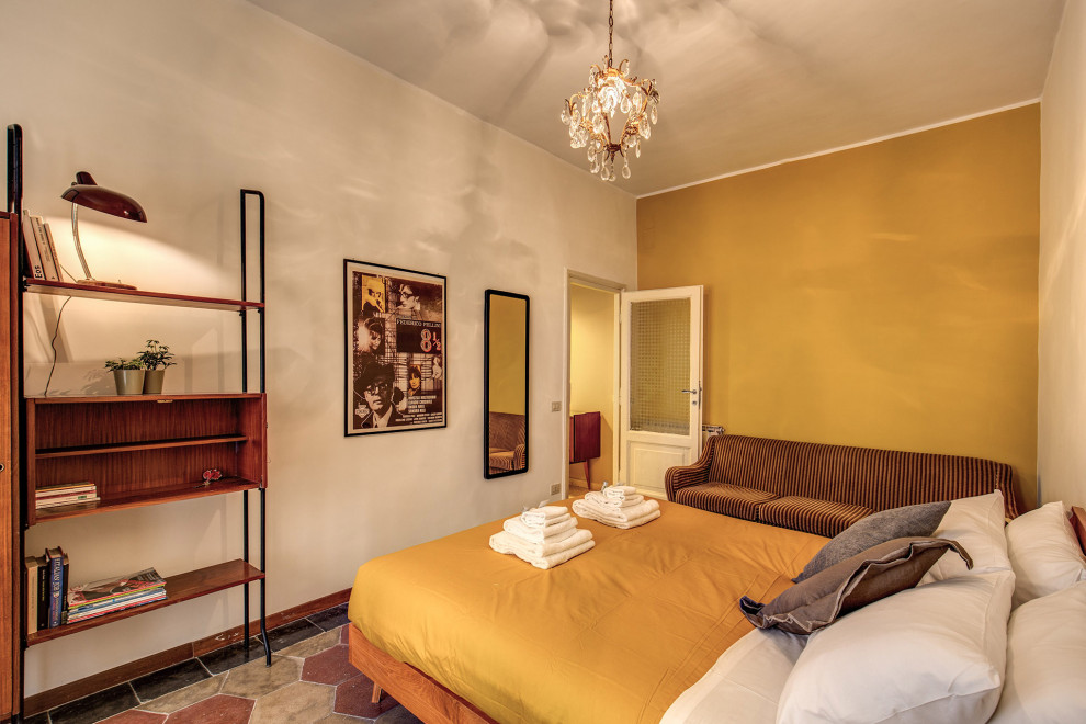 Foto di una camera matrimoniale minimalista di medie dimensioni con pareti gialle, pavimento in cemento e pavimento multicolore