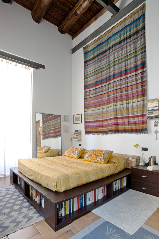 На фото: хозяйская спальня в стиле фьюжн с белыми стенами и полом из терракотовой плитки с