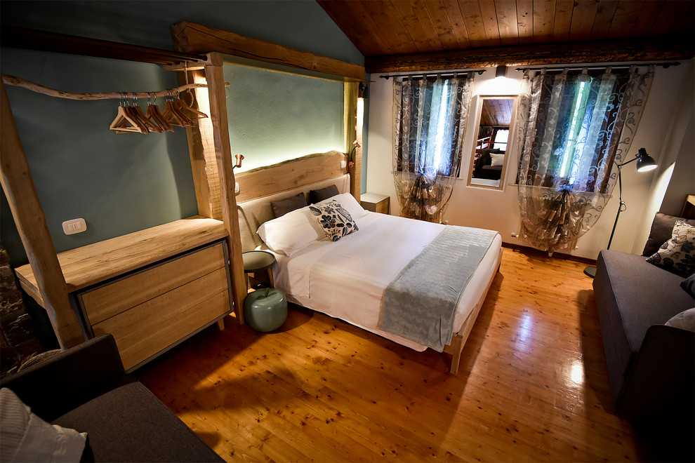 Immagine di una grande camera da letto stile loft country con pareti blu, pavimento in legno verniciato e pavimento beige