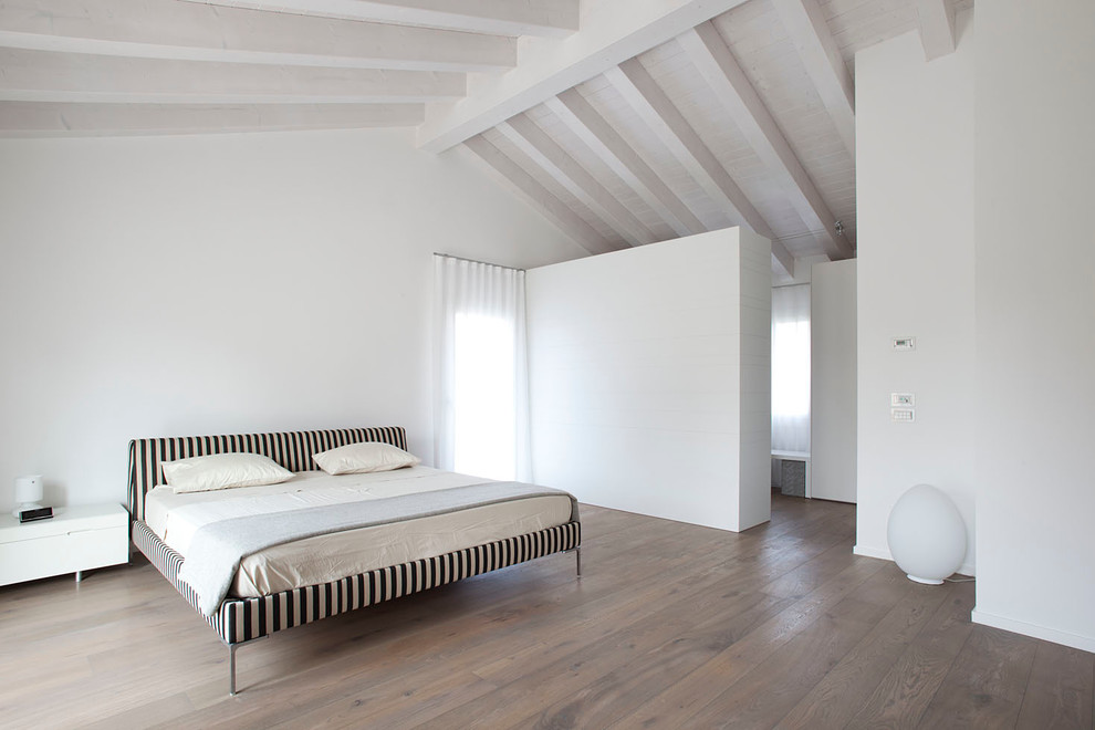 Expansive contemporary master loft bedroom in Venice with white walls and medium hardwood flooring.