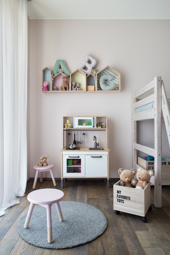 Imagen de dormitorio infantil de 4 a 10 años escandinavo de tamaño medio con suelo de madera oscura y paredes rosas
