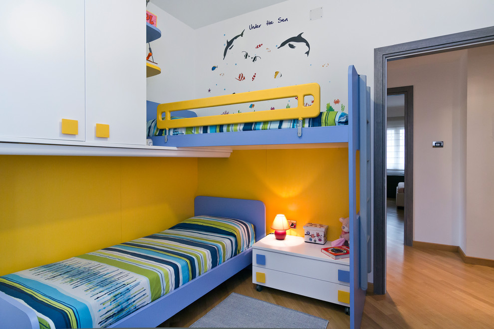 На фото: детская среднего размера в современном стиле с спальным местом, белыми стенами и светлым паркетным полом для ребенка от 1 до 3 лет, мальчика с