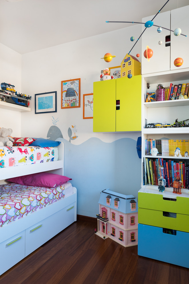 Réalisation d'une petite chambre d'enfant de 4 à 10 ans design avec un mur blanc, un sol en bois brun et un sol marron.