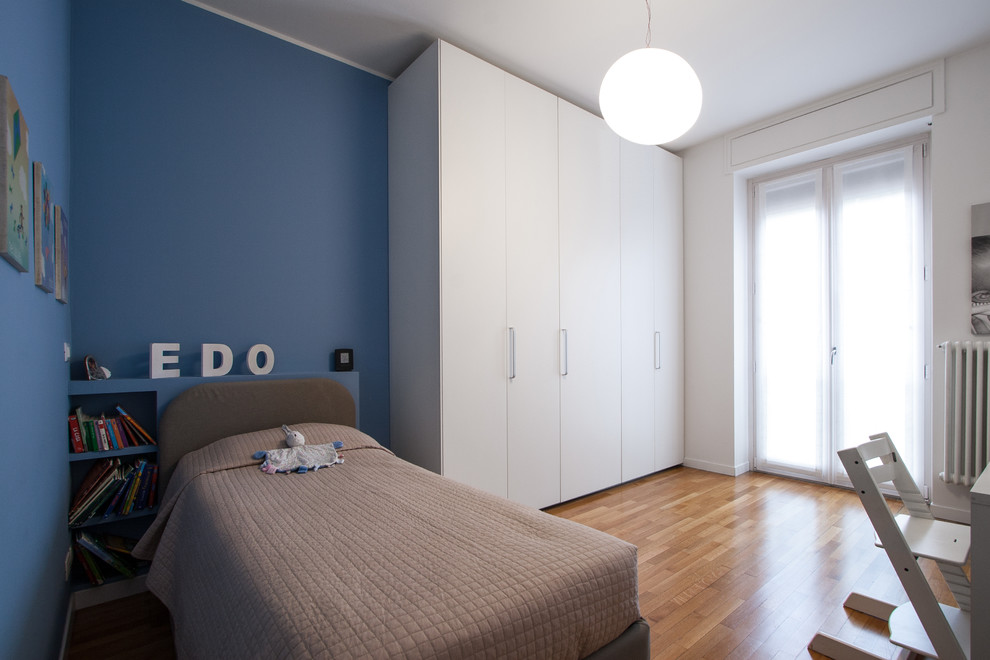 Immagine di una grande cameretta da letto da 4 a 10 anni contemporanea con pareti blu, pavimento in legno massello medio e pavimento marrone