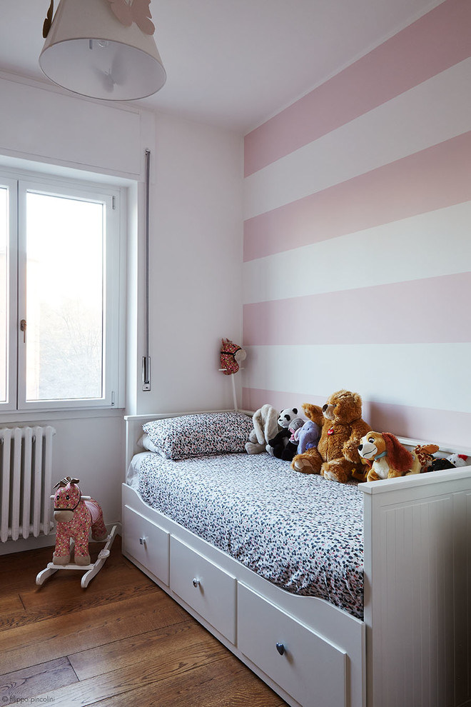 На фото: маленькая детская в стиле модернизм с спальным местом, розовыми стенами, темным паркетным полом и коричневым полом для на участке и в саду, ребенка от 4 до 10 лет, девочки с