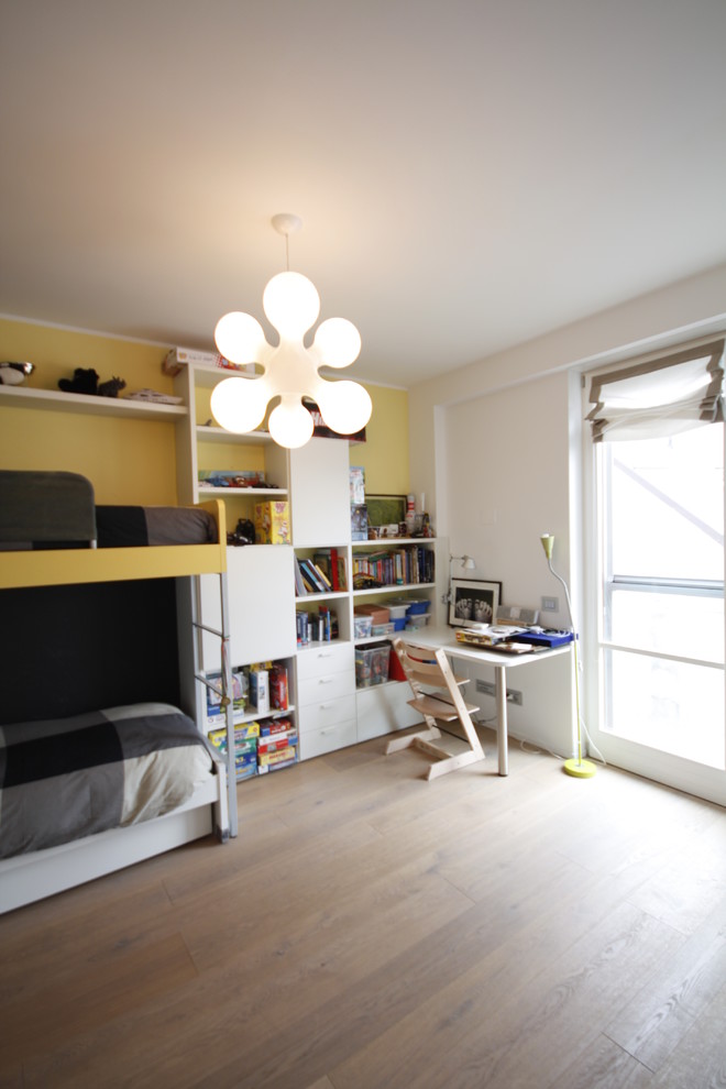 Foto di una cameretta per bambini minimalista di medie dimensioni con pareti gialle, parquet chiaro e pavimento marrone