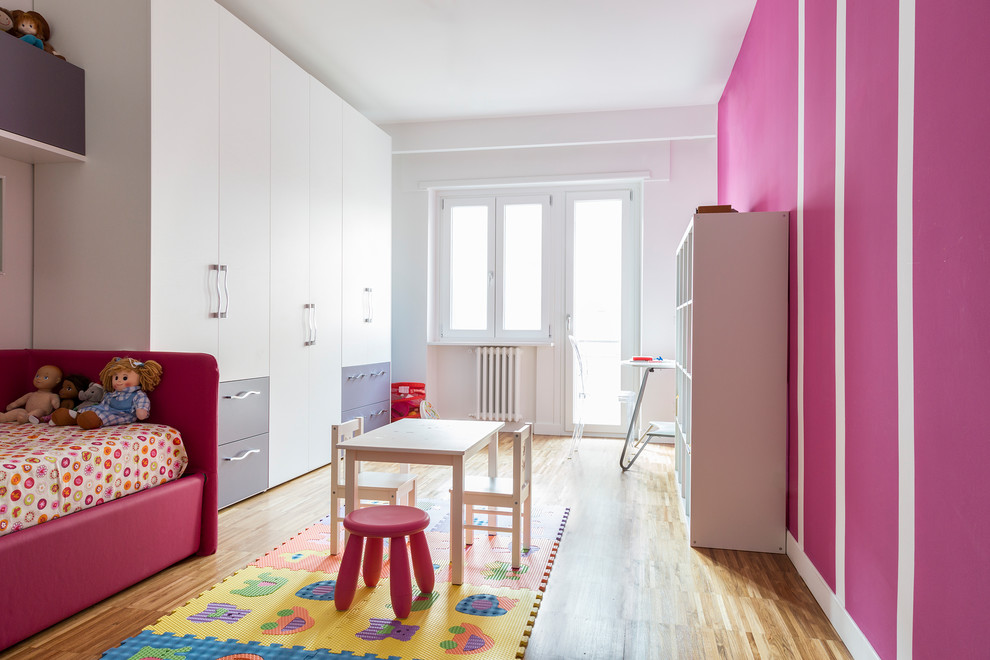 Esempio di una grande cameretta per bambini da 4 a 10 anni contemporanea con pavimento in legno massello medio, pavimento beige e pareti rosa