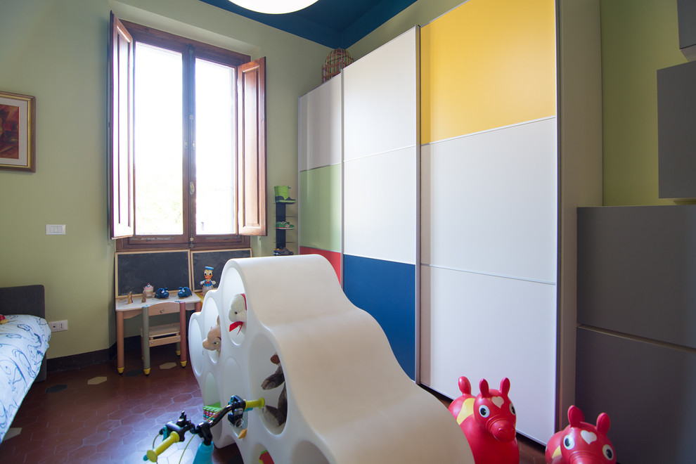 На фото: нейтральная детская с игровой среднего размера в современном стиле с разноцветными стенами и полом из терракотовой плитки для ребенка от 1 до 3 лет с